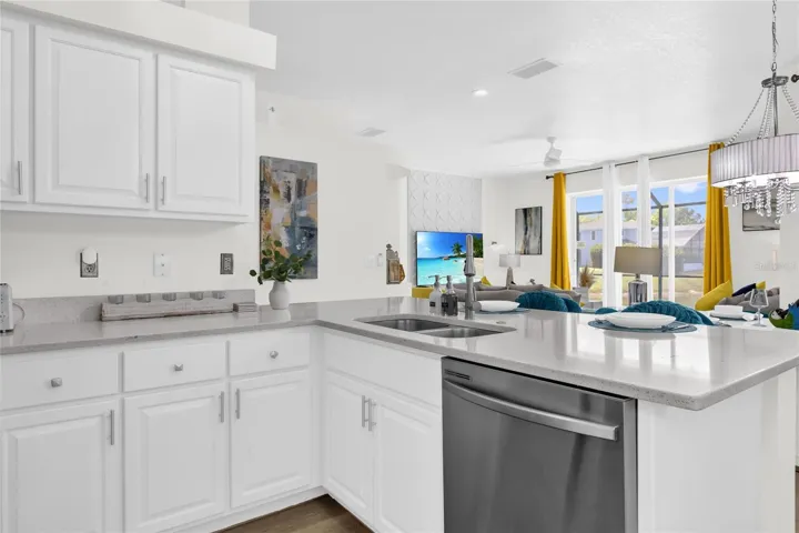 Bright, open-concept kitchen with quartz countertops, ample cabinetry, stainless steel appliances, and a seamless flow into the main living areas—perfect for entertaining