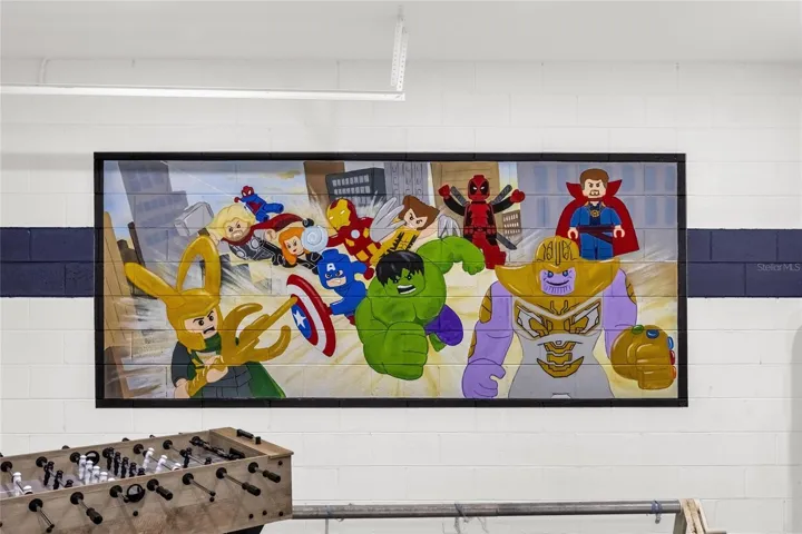 Custom themed game room with vibrant wall art for added guest appeal