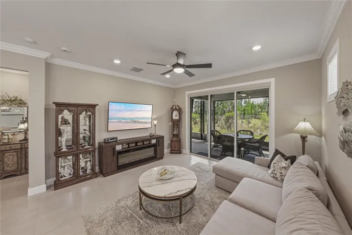 Great Room with upgraded lighting package and crown molding and solar shade