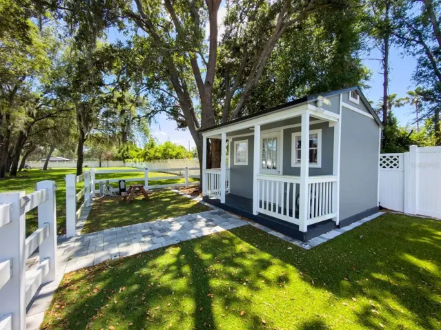 A charming farmhouse-style private cottage tucked beneath mature trees, offering a serene and versatile space for guests, work, or quiet moments.
