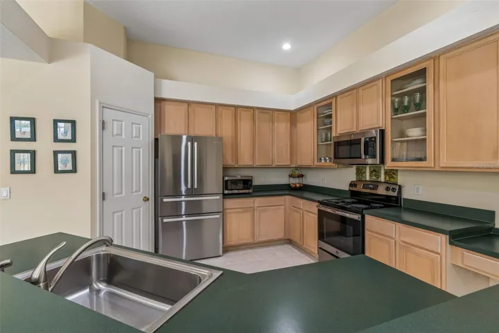 Kitchen overlooking the family room, breakfast noon, and pool