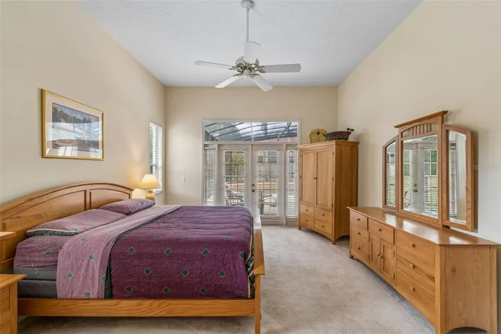 Primary suite overlooking the pool, featuring two closets and an ensuite bathroom with dual vanities, a walk-in shower, a garden tub, and a private water closet