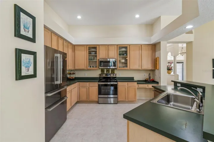 Kitchen overlooking the family room, breakfast noon, and pool