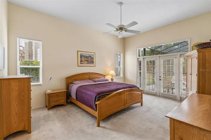 Primary suite overlooking the pool, featuring two closets and an ensuite bathroom with dual vanities, a walk-in shower, a garden tub, and a private water closet