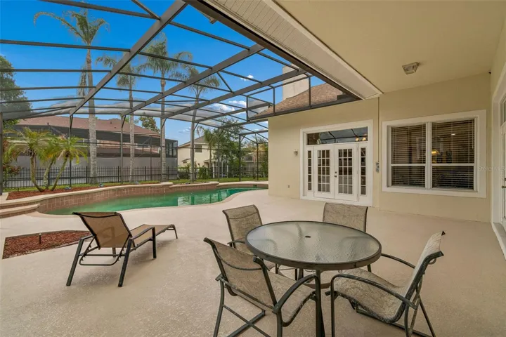 Spacious outdoor pool area featuring a 27’ x 9’ covered patio and a resort-style pool within a screened enclosure