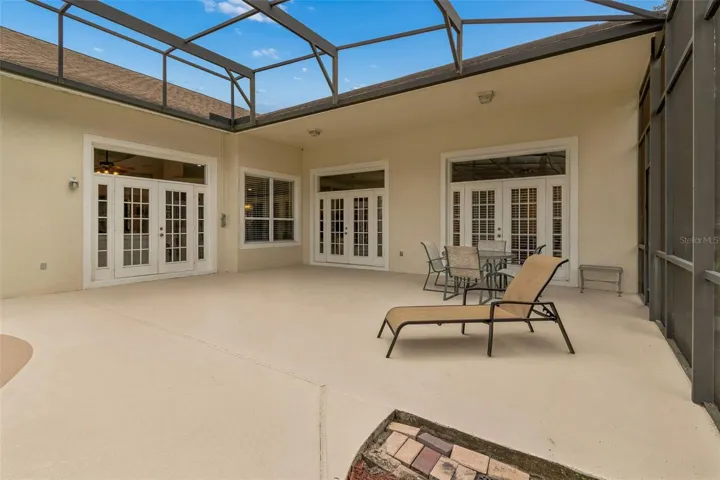 Spacious outdoor pool area featuring a 27’ x 9’ covered patio and a resort-style pool within a screened enclosure