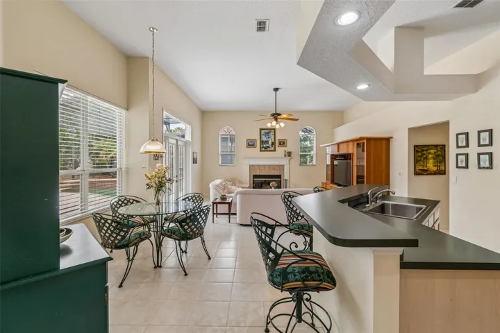 Kitchen overlooking the family room, breakfast noon, and pool