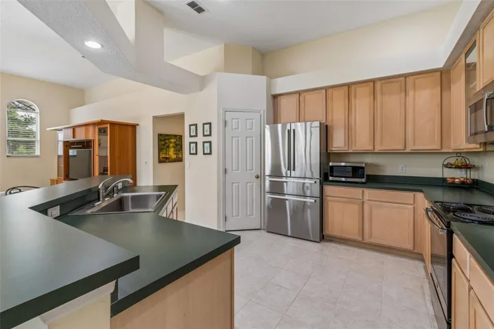 Kitchen overlooking the family room, breakfast noon, and pool