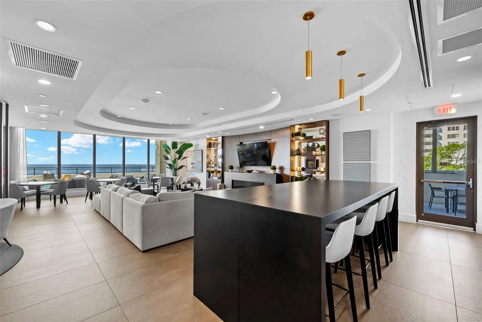 Residents club room located on the amenities deck offers views of the pool and the Bay with easy access to the outdoor kitchen and gathering space.