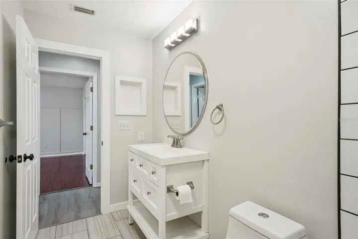 The second bathroom includes a tub/shower combination with large subway tile and a rain shower head.