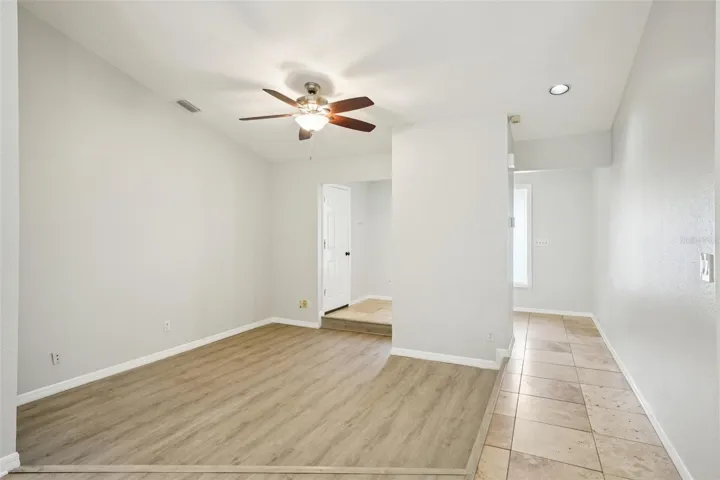 Formal sunken living room with vaulted ceilings and luxury vinyl flooring off foyer and family room and kitchen.