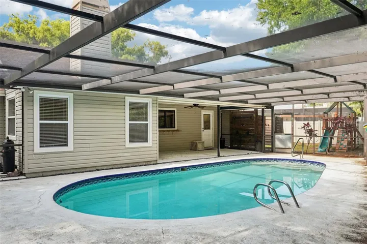 The screened-in pool area includes a covered area to sit and relax with a sparkling Pebble Tec pool to cool off in and enjoy the Florida weather.