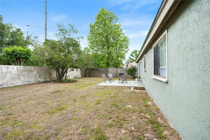 The back yard is enclosed with the wall in the back and wooden fences on each side.
