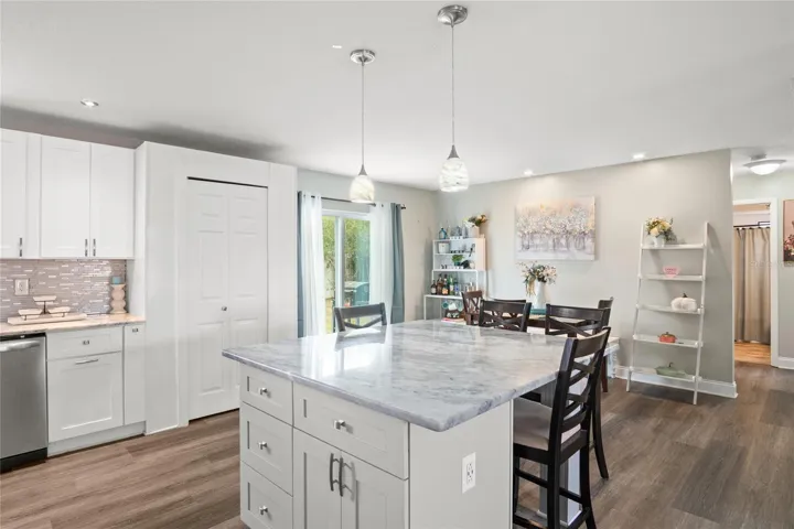 The kitchen island can be used as a place to eat, a place for gathering friends at a party, or for preparing a meal. The outlet at the end along with storage space comes in handy.