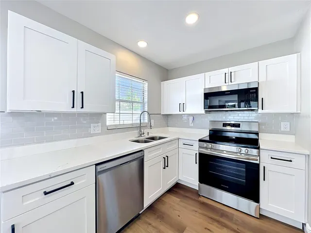 Quartz Countertops, while shaker cabinets, stainless steel  appliances