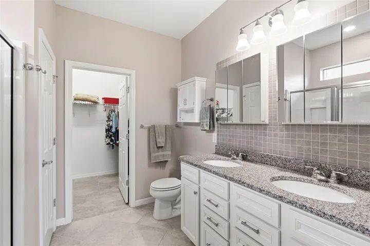 Primary Bathroom with double vanity sink and upgraded backsplash