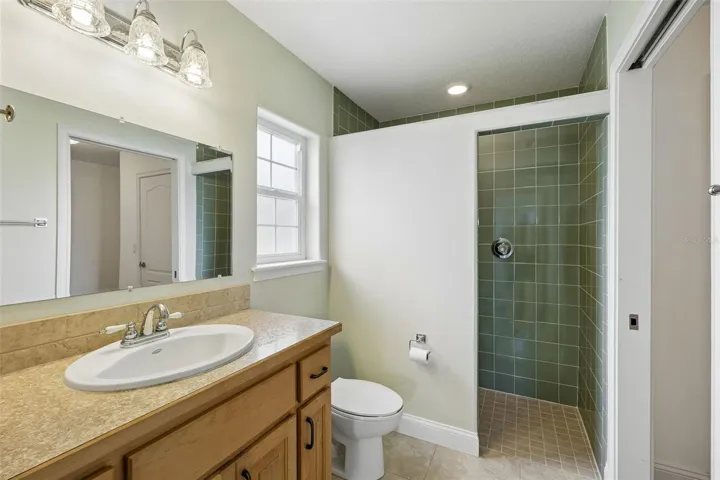 Includes a bathroom with tastefully tiled walk-in shower