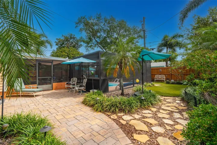 The grounds have been thoughtfully curated with pavered paths, multiple sitting areas, and lush tropical landscaping.