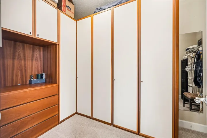 Primary walk-in closet with custom built Italian storage cabinets.