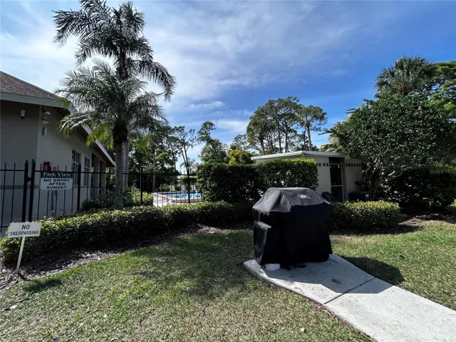 Outdoor gas grill behind clubhouse and pool