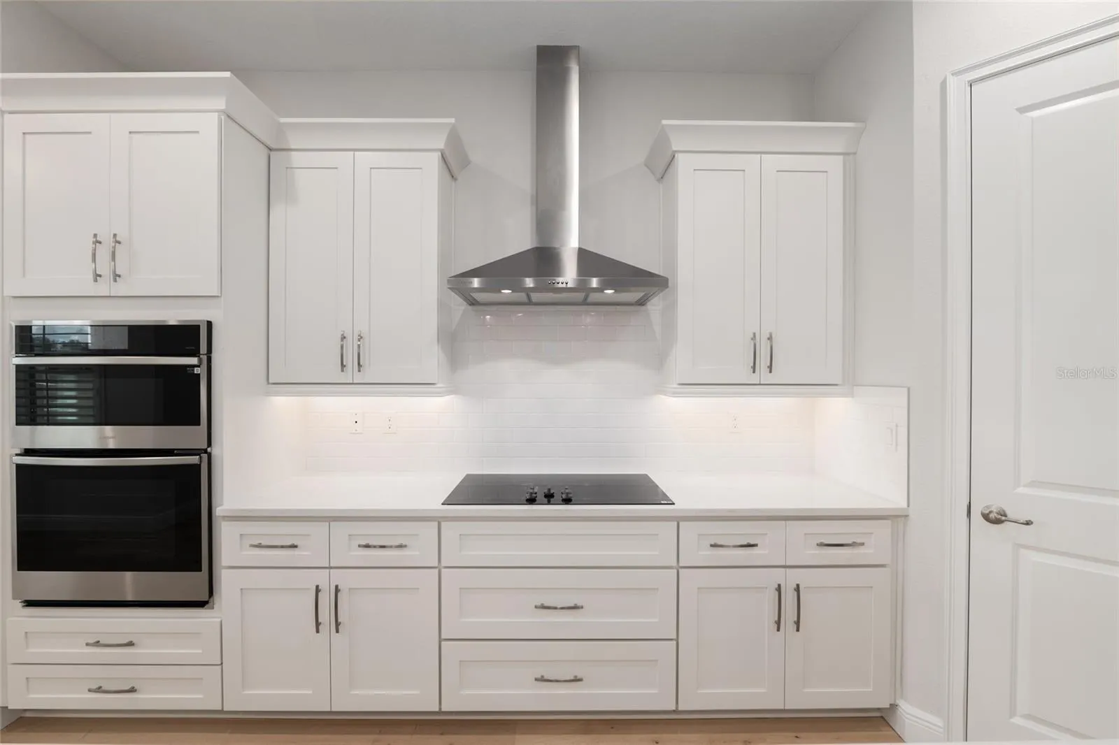 Range hood, cooktop, single wall oven with microwave above.