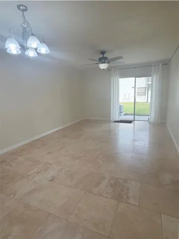 The living room is 20x12 and features travertine floors and a newer fan and lighting fixture.