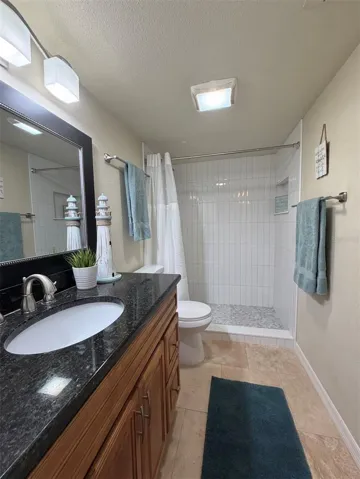 The primary ensuite features travertine floors, solid wood cabinets, granite counters, updated lighting, and an updated walk-in shower, remodeled on Oct 2025.