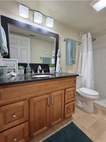 The primary ensuite features travertine floors, solid wood cabinets, granite counters, updated lighting, an updated mirror, and a newly remodeled walk-in shower.