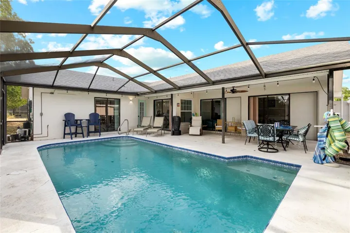 Jump into this gorgeous well maintained screened in pool.  This 3 bedroom, 2 bathroom cement block pool home with vaulted ceilingso & new roof, ffers 4 sets of sliding glass doors that lead to the lanai and pool area