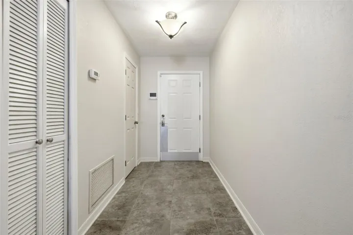 Foyer - entry into condo with a coat closet