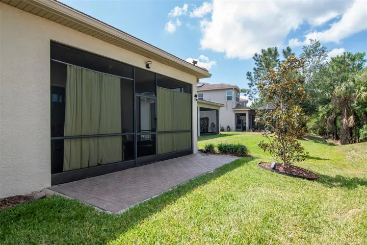 Back exterior featuring lanai and extended paver patio