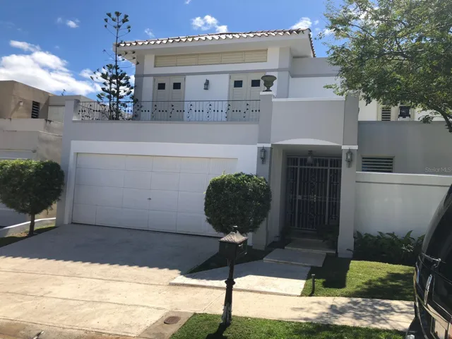 Elegant two-story residence located in the exclusive gated community of Mansiones Reales in Guaynabo. This property showcases clean architectural lines, a spacious double garage, and a well-maintained front garden, offering strong curb appeal and privacy.