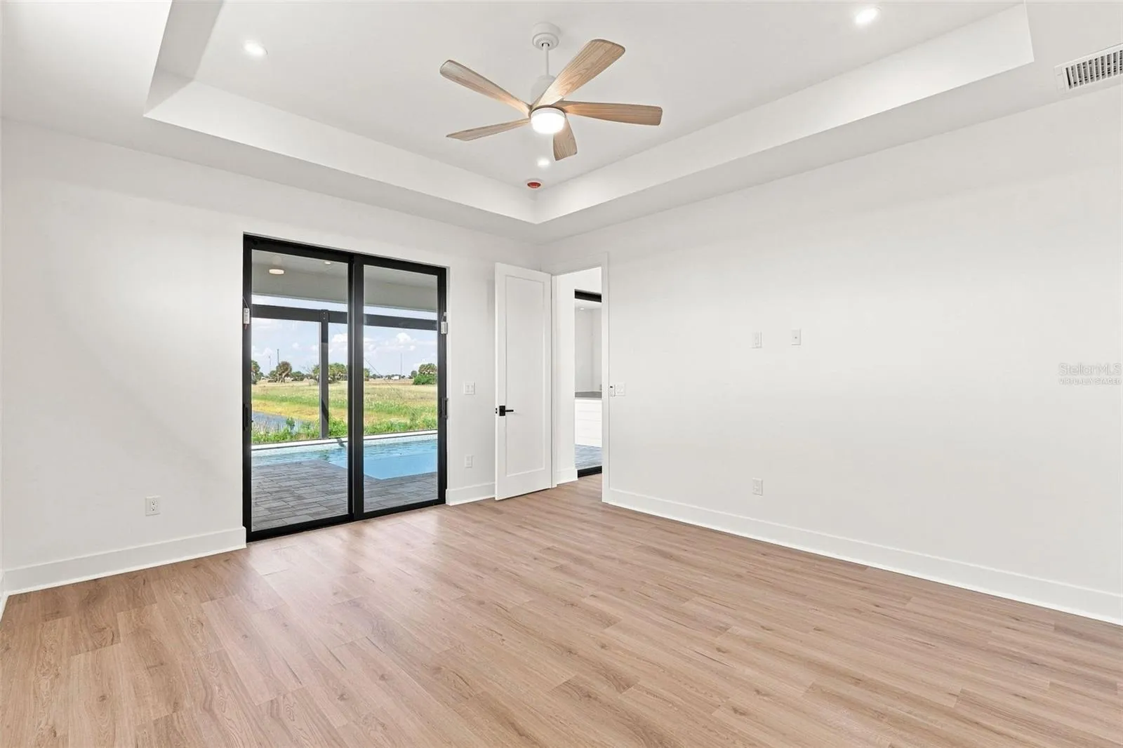 Virtually Staged Primary Suite with Tray Ceiling & Patio Access