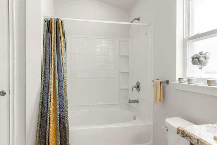 The ensuite bath includes a soaking  tub with shower, dual vanities, and a privacy window that fills the space with natural light.