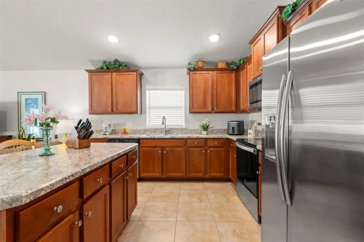 Additional kitchen highlights include abundant cabinetry, expansive counter space, recessed lighting, and a French-door refrigerator with built-in water and ice dispenser.