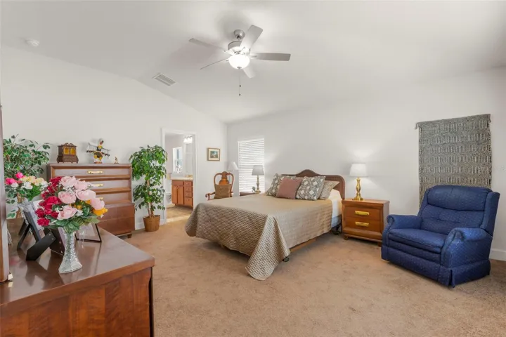 Vaulted ceilings and expansive dimensions enhance the spacious primary suite, offering flexibility for both traditional bedroom furnishings and a private sitting area.