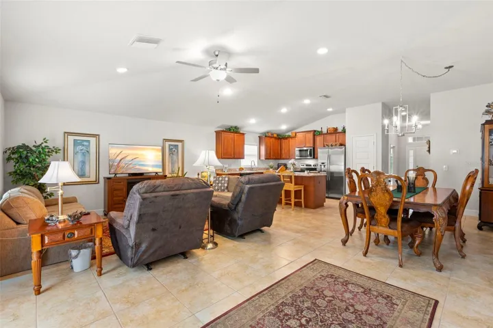 The expansive open-concept living and dining area flows seamlessly into the kitchen, highlighted by elevated ceiling height, oversized tile flooring, and an airy layout designed for comfortable daily living and effortless entertaining.