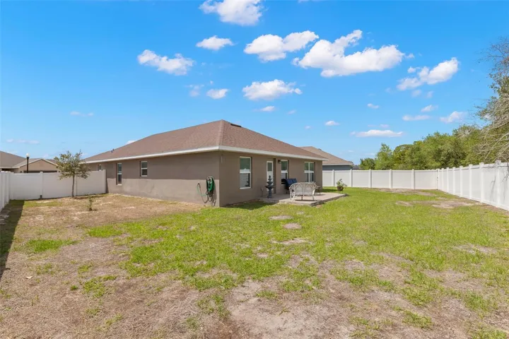 The oversized vinyl-fenced backyard offers abundant open green space, an expansive side yard, and endless flexibility for pets, play, gardening, or future outdoor enhancements.