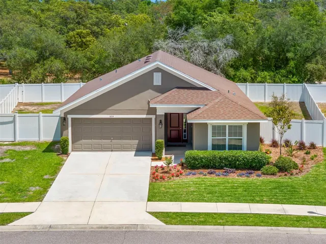 Bird’s-eye view showcases the home’s premium lot placement, expansive fenced yard, and private wooded backdrop.