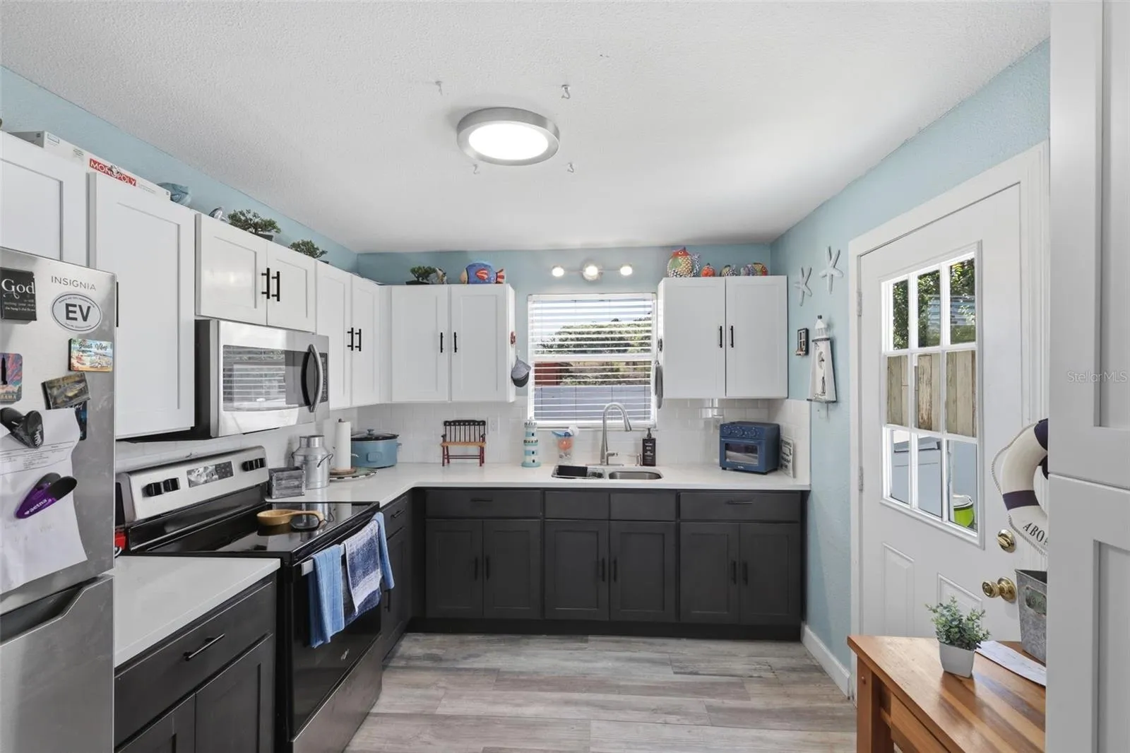View of entire kitchen with stainless steal appliances.