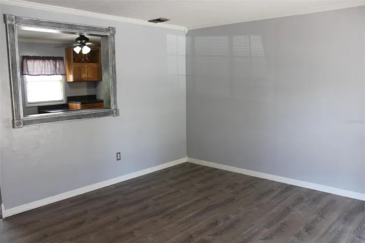 Living room has a pass through window to the kitchen hinting at an open concept for the living room/ kitchen areas.
