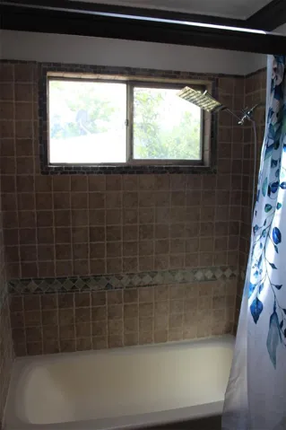The main bathroom has upgraded shower wall tiles and an upgraded shower head.