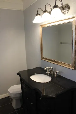 The half bath off the primary bedroom with new vanity, new mirror and light fixture!