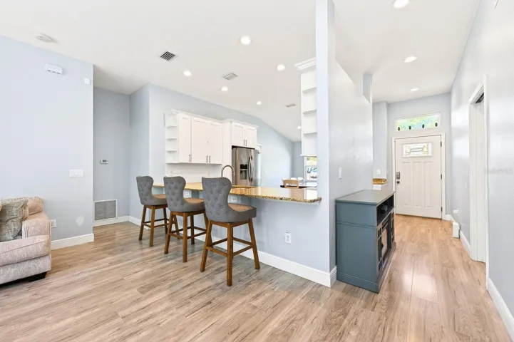 A covered front entry with stacked stone accents sets the tone as you step inside to a light, bright seamless layout highlighted by VAULTED CEILINGS and an easy, natural flow.