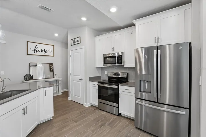 The heart of the home is the stunning Kitchen, thoughtfully designed with 42-inch white cabinetry, solid-surface countertops, stainless steel appliances, a stylish tile backsplash, closet pantry, UNDER-SINK REVERSE OSMOSIS SYSTEM (2024), and a charming breakfast nook.