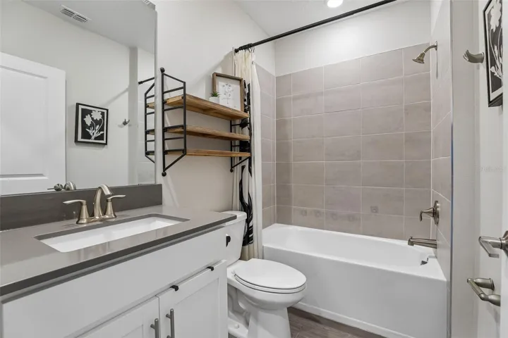 Two additional bedrooms are situated near another full bath.