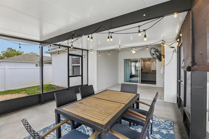 Sliding glass doors open to a covered patio with an 18x15 SCREEENED ENCLOSURE (2024)—an inviting extension of the home's living space and the perfect place to enjoy morning coffee, outdoor dining, or relaxing evenings.