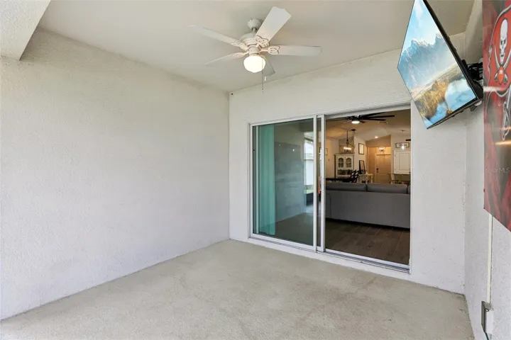 Sliding glass doors open to a covered patio with an 18x15 SCREEENED ENCLOSURE (2024)—an inviting extension of the home's living space and the perfect place to enjoy morning coffee, outdoor dining, or relaxing evenings.