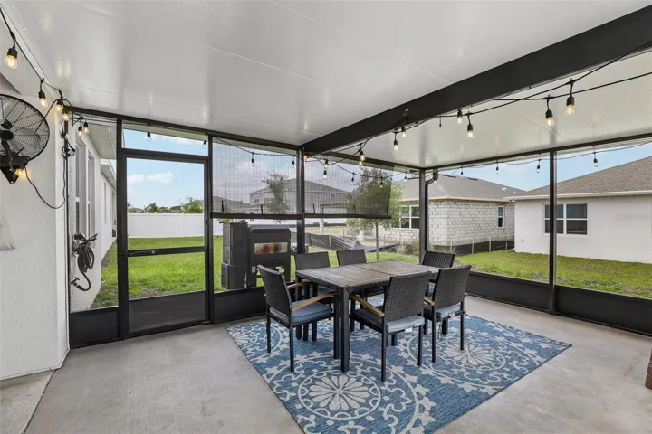Sliding glass doors open to a covered patio with an 18x15 SCREEENED ENCLOSURE (2024)—an inviting extension of the home's living space and the perfect place to enjoy morning coffee, outdoor dining, or relaxing evenings.