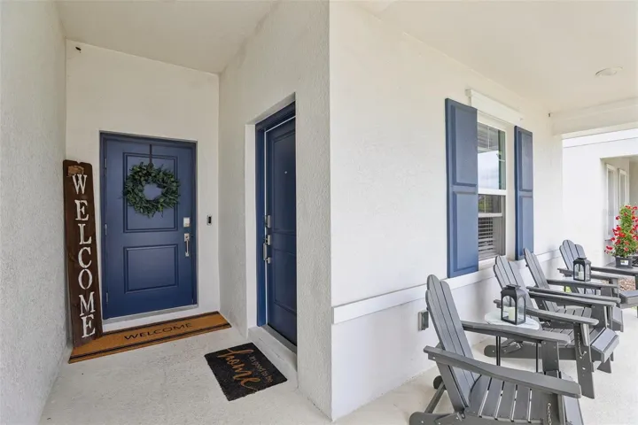 A CHARMING FRONT PORCH and attractive paver driveway create a welcoming first impression.